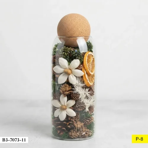 BOUTEILLE-EN-VERRE-REMPLIE-DE-POMMES-DE-PIN-ET-ELEMENTS-NATURELS